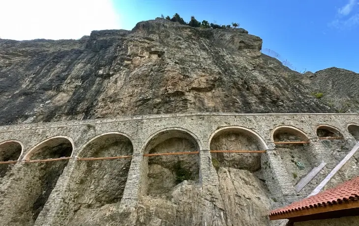 Sümela Manastırı’nın dik vadi yamacına yaslanan su kemeri; çoklu kemer açıklıkları, taş örgü yapısı ve kayalık yüzeyle birleşen tarihi su yolu.